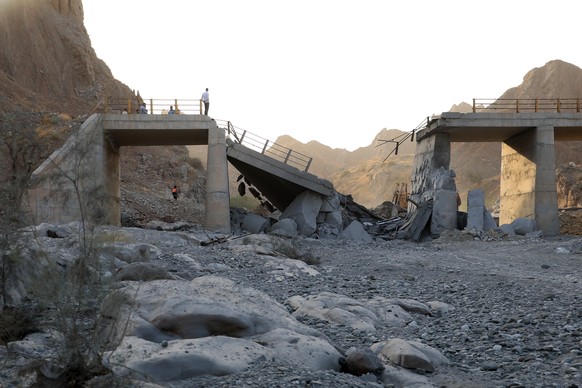 epa13119481 A handout photo made available by the Iranian Students News Agency (ISNA) shows officials standing on a bridge damaged by a US strike on the road between Rudan and Bandar Abbas in souther ...