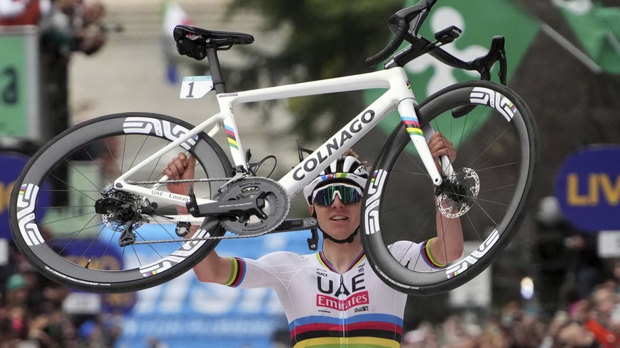 Reigning World Champion Slovenia&#039;s Tadej Pogacar holds up his bike as he celebrates winning Il Lombardia, Tour of Lombardy cycling race, in Como, Italy, Saturday, Oct. 12, 2024. (Gian Mattia D&#0 ...
