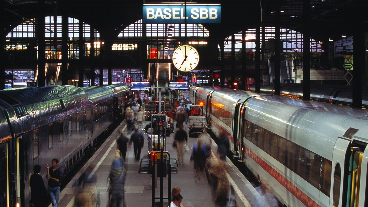 ZUM 75-JAEHRIGEN JUBILAEUM DER SBB BAHNHOFUHR (1944) STELLEN WIR IHNEN FOLGENES BILDMATERIAL ZUR VERFUEGUNG --- Auf dem Bahnsteig im Bahnhof Basel sind Reisende in der Abenddaemmerung auf dem Weg zu i ...