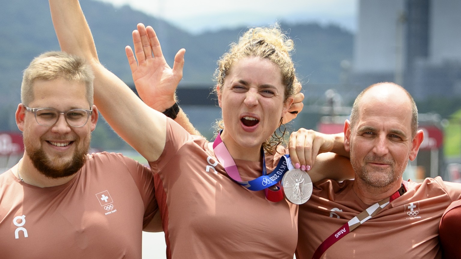 Silver medal winner Marlen Reusser, center, of Switzerland poses for photographer with her national coach Edi Telser, right, and her mechanic Cedric Staehli, left, after the victory ceremony of the wo ...