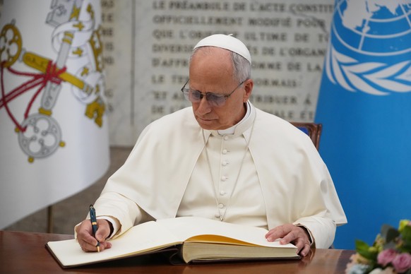 Pope Leo XIV signs the FAO Golden Book register of honor as he attends a ceremony marking the 80th anniversary of World Food Day at the FAO headquarters in Rome, Thursday, Oct. 16, 2025. (AP Photo/Ale ...