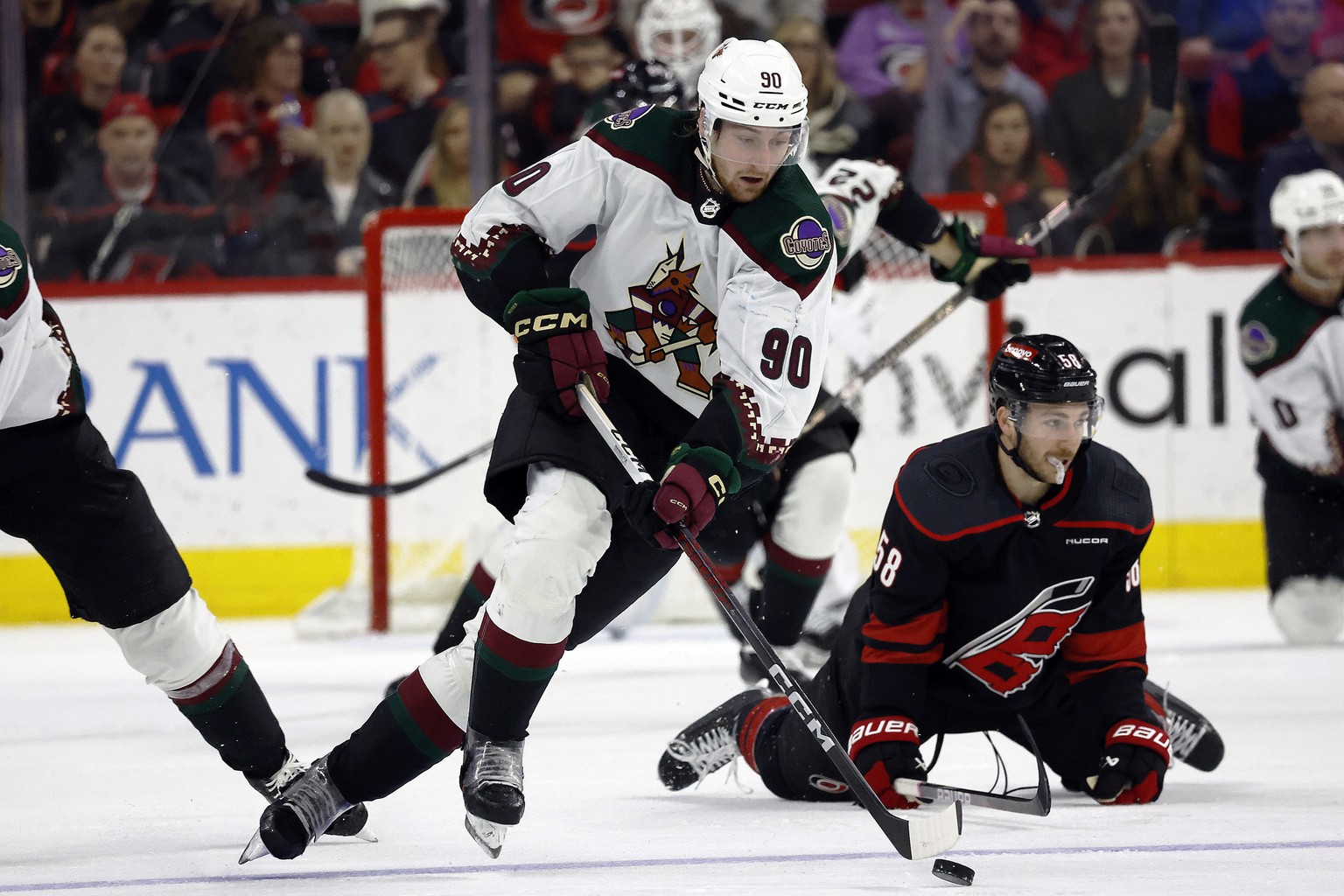 Arizona Coyotes&#039; J.J. Moser (90) skates away from Carolina Hurricanes&#039; Michael Bunting (58) with the puck during the third period of an NHL hockey game in Raleigh, N.C., Saturday, Jan. 27, 2 ...