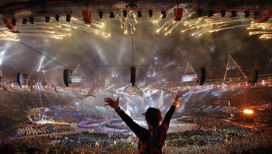 epa03374426 A spectator cheers fireworks going off over the Olympic Stadium during the opening ceremony of the London 2012 Paralympic Games, London, Britain, 29 August 2012. EPA/TAL COHEN