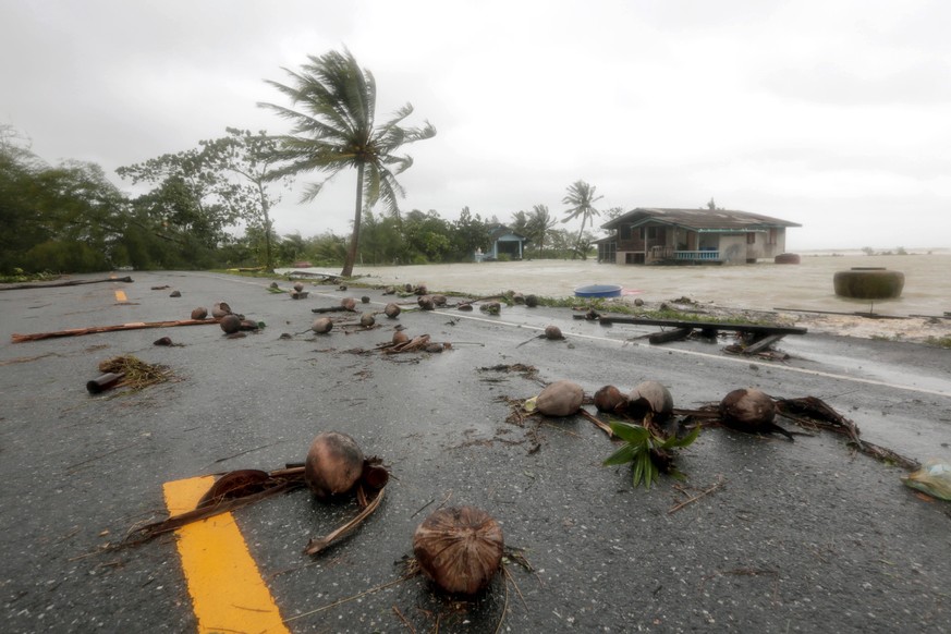 epaselect epa07261520 A view of debris on a road and a house (back) partially submerged in floodwaters caused by tropical storm Pabuk at a village in Pak Phanang district, Nakhon Si Thammarat province ...