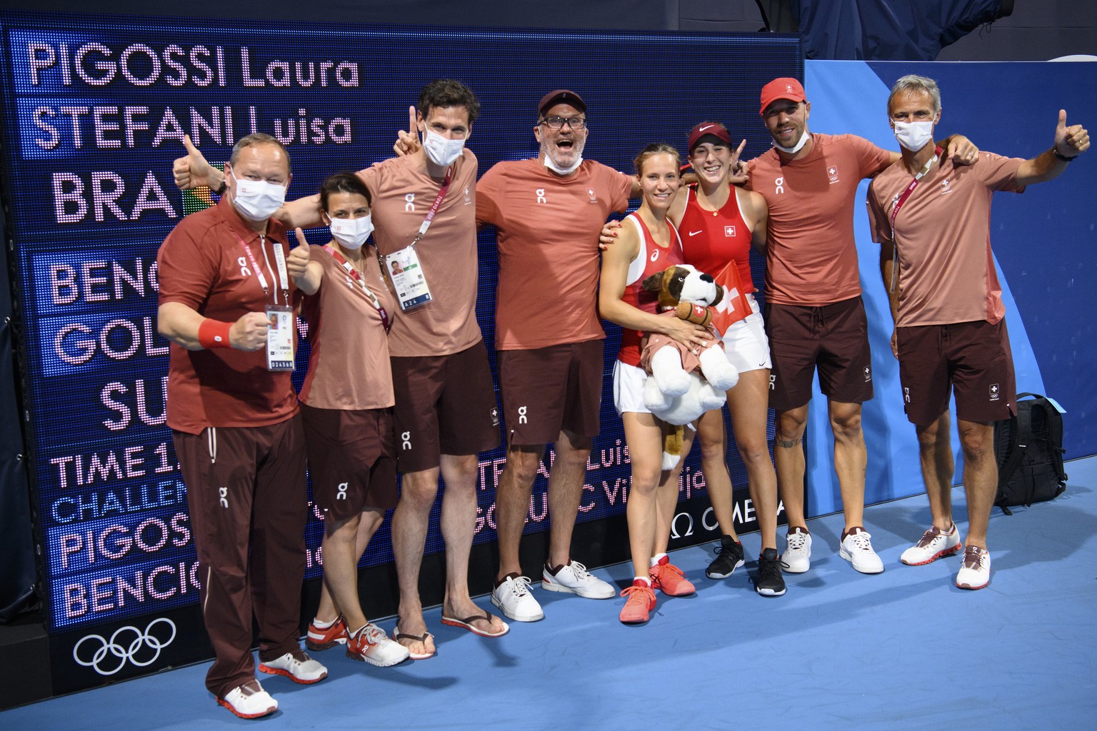 Belinda Bencic, third from right, and Viktorija Golubic, fourth from right, of Switzerland celebrate with the Swiss mascot dog Barry and the delegation of Swiss Olympic after winning against Laura Pig ...