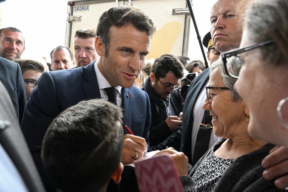 epa09916514 French President Emmanuel Macron (C) meets people in Barbazan-Debat market at place de l?Eglise, in Barbazan-Debat village, Hautes-Pyrenees, France, 29 April 2022.Macron meets the inhabita ...