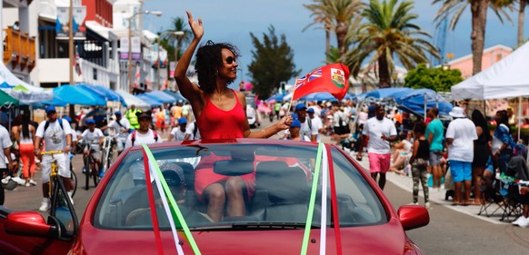 epa05987288 A marshal of the Bermuda Day Parade waves to spectators during Bermuda Day in Hamilton, Bermuda, 24 May 2017.The country of Bermuda is the host of the 35th America&#039;s Cup starting 26 M ...