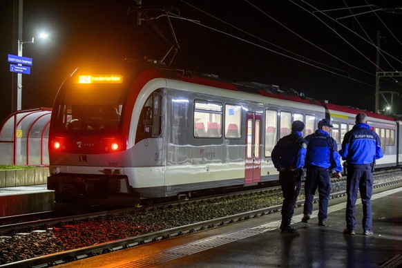 Vaud cantonal police officers watch the Travys train where a hostage-taking incident took place at Essert-sous-Champvent station, Switzerland, Thursday, 8, February, 2024. A hostage-taking incident to ...