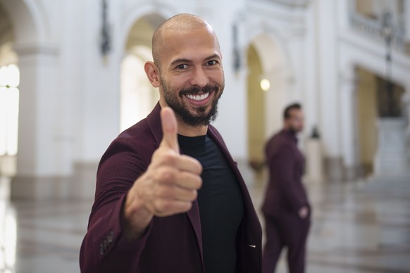 Andrew Tate poses giving a thumbs up upon arriving with his brother Tristan, right, at the Court of Appeals building in Bucharest, Romania, Tuesday, Oct. 15, 2024. (AP Photo/Vadim Ghirda)