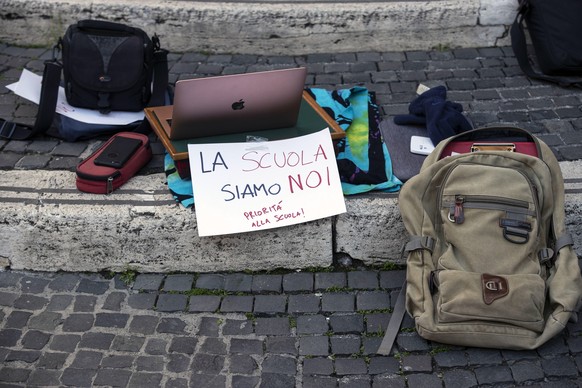 epa08832394 Scholl bags and material are displayed with protest placards as students of the Visconti high school stage a sit-in against distance learning, amid the second wave of the Covid-19 coronavi ...