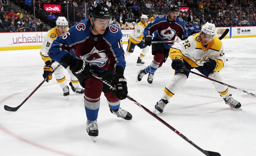 Colorado Avalanche defenseman Nikita Zadorov, front, clears the puck from his zone as Nashville Predators center Kyle Turris, back left, and left wing Kevin Fiala defend in the second period of an NHL ...