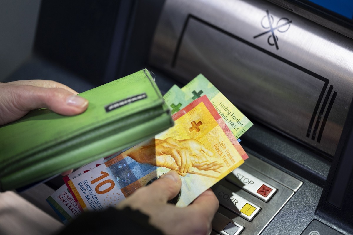 Eine Person kontrolliert den am Geldautomaten abgehobenen Betrag in Schweizer Franken und steckt die Banknoten in ihr Portemonnaie, aufgenommen am Montag, 26. Januar 2026 in Zuerich. (KEYSTONE/Gaetan  ...