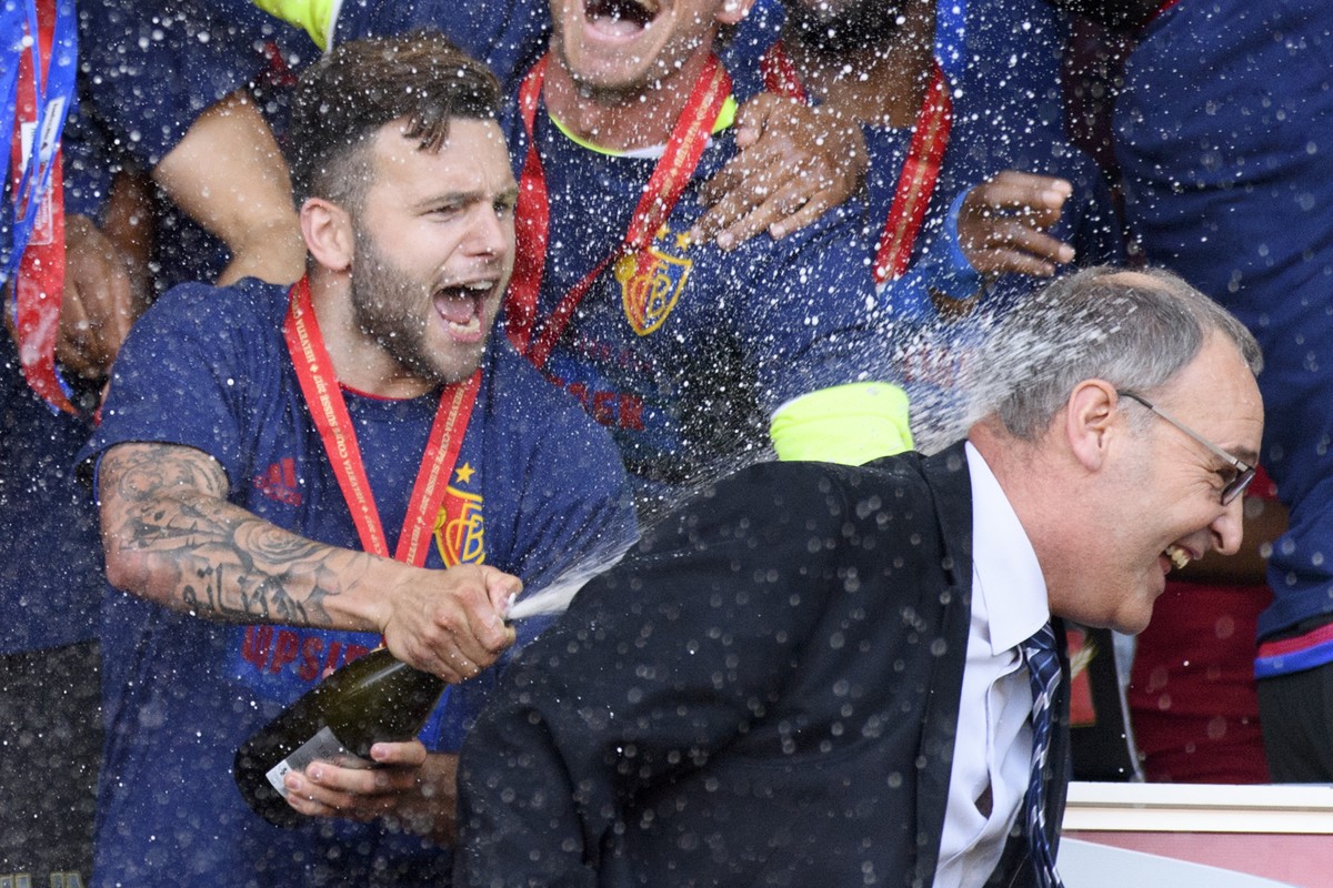 Basel's midfielder Renato Steffen, left, sprays with champagne Federal councillor Guy Parmelin, right, as Basel's players celebrate with the trophy after winning the the Swiss Cup final socc ...