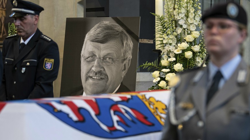 FILE-In this June 13, 2019 file photo a picture of Walter Luebcke stands behind his coffin during the funeral service in Kassel, Germany. German authorities say they have arrested a 45-year-old man in ...