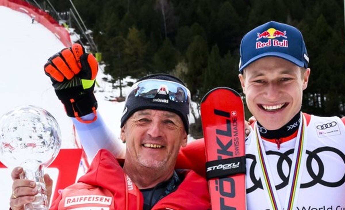 Marco Odermatt of Switzerland celebrates with the men's giant slalom overall leader crystal globe trophy with his giant slalom coach, Helmut Krug, left, and members of Swiss-ski federation after  ...