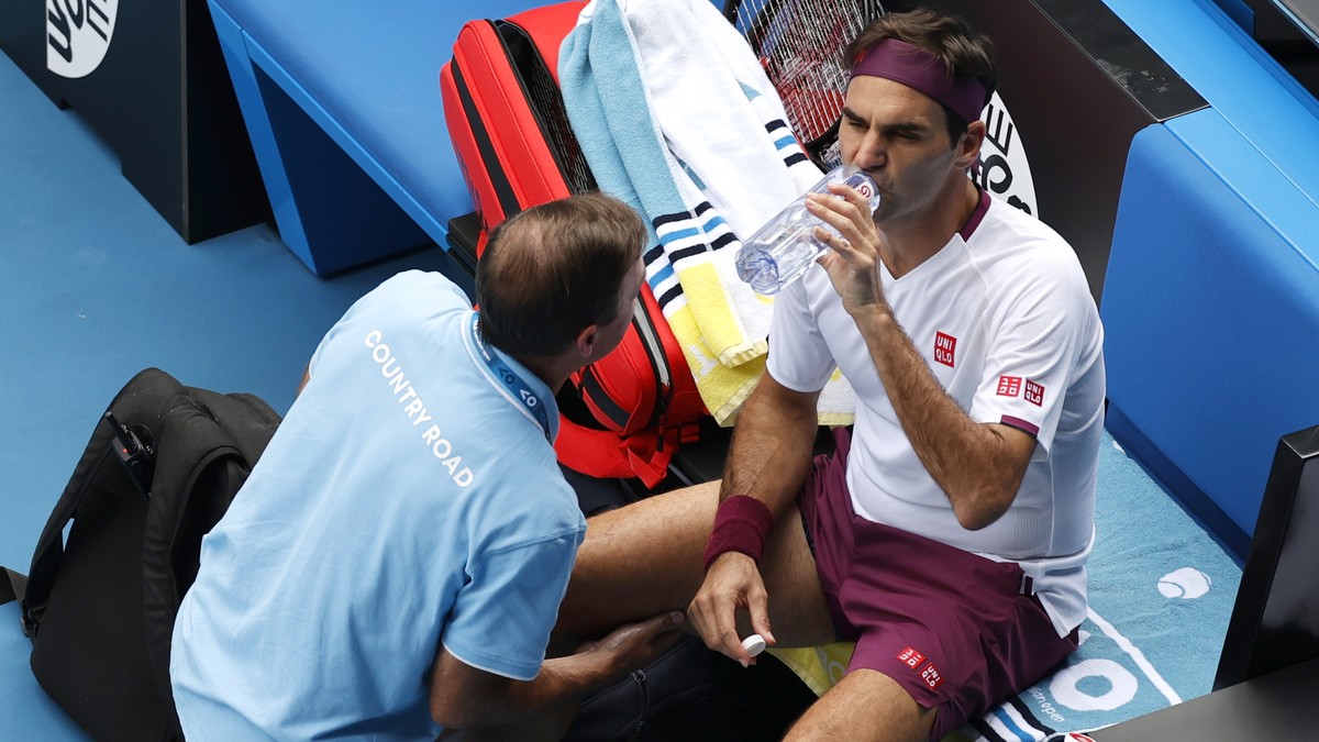 Switzerland's Roger Federer receives treatment from a trainer during his quarterfinal against Tennys Sandgren of the U.S. at the Australian Open tennis championship in Melbourne, Australia, Tuesd ...
