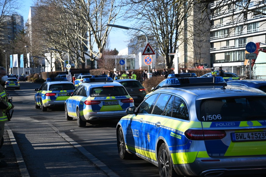 Police vehicles are parked on the grounds of Heidelberg University in Heidelberg, Germany, Monday, Jan. 24, 2022. German police say a lone gunman wounded several people at a lecture theatre in the sou ...