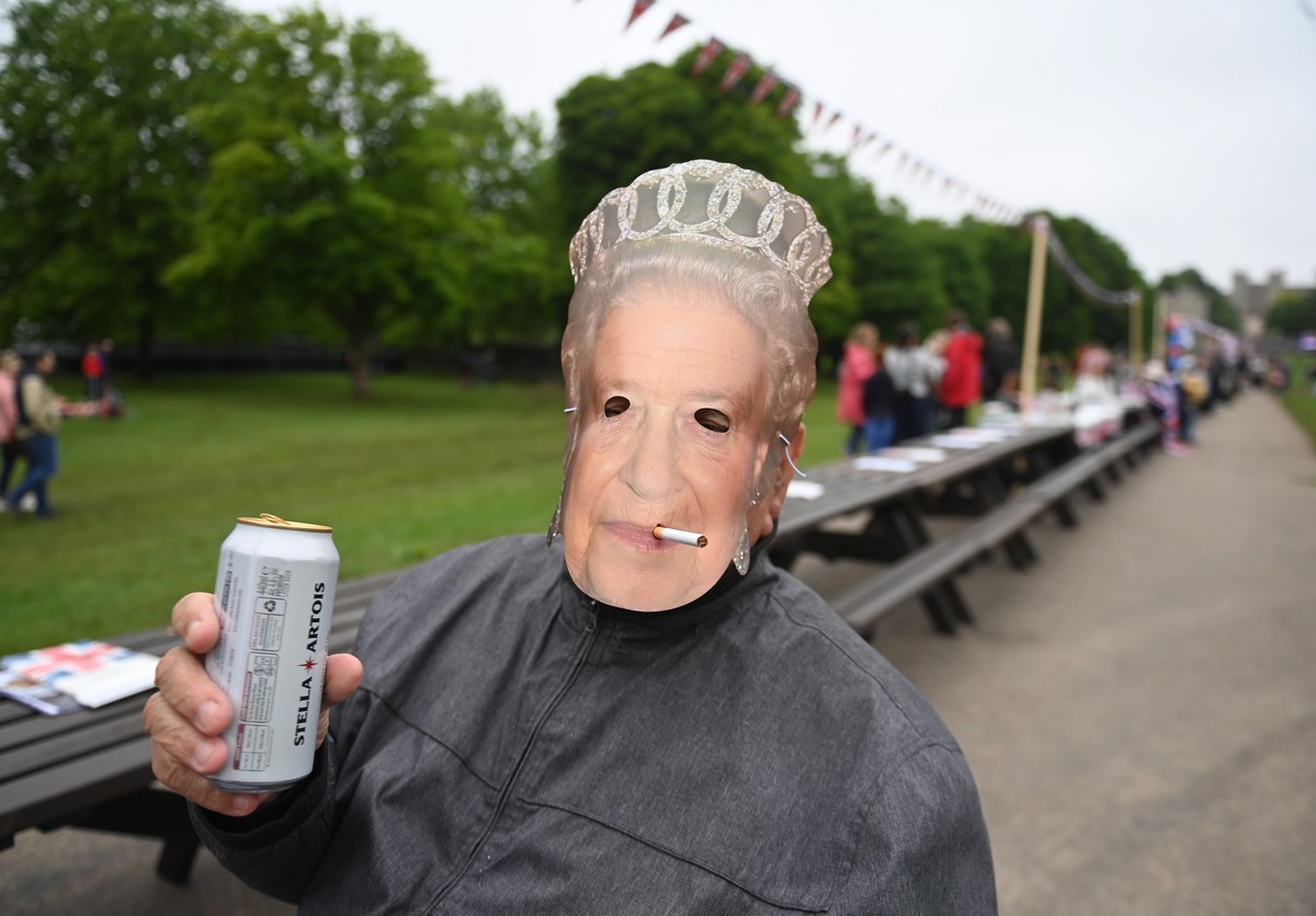 epa09997105 A man wearing a Queen mask enjoys a picnic during The Big Lunch on the Long Walk during the celebrations of the Platinum Jubilee of Britain's Queen Elizabeth II, in Windsor, Britain,  ...