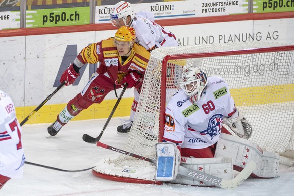 Tigers Topscorer Harry Pesonen, links, kaempft um den Puck gegen Rapperswils Steve Mason, Mitte rechts, und Goalie Melvin Nyffeler, rechts, waehrend dem Meisterschaftsspiel der National League zwische ...