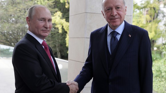 epa09495169 Russian President Vladimir Putin (L) welcomes Turkish President Recep Tayyip Erdogan during their meeting at the Bocharov Ruchei residence in Sochi, Russia, 28 September 2021. According to ...