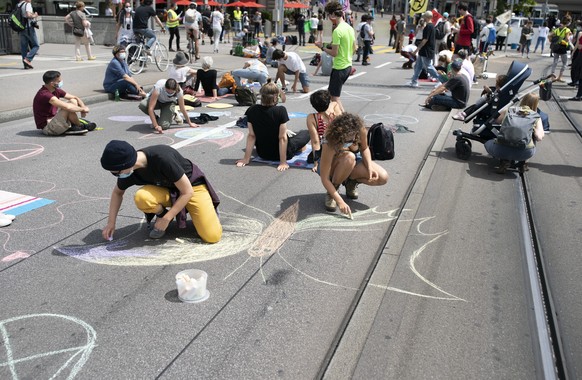 epa08497391 epa08497186 Activists from the global environmental movement Extinction Rebellion draw on the ground during a protest on the Quaibruecke in Zurich, Switzerland, 20 June 2020. EPA/GAETAN BA ...