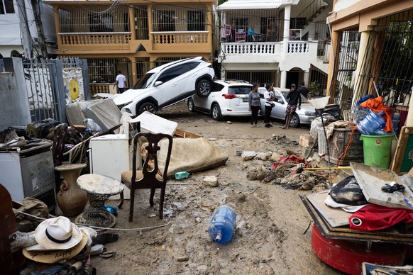 epa10985361 People view the damage to buildings and vehicles after torrential rains in Santo Domingo, Dominican Republic, 19 November 2023. Torrential rains since 17 November have forced nearly 8,000  ...