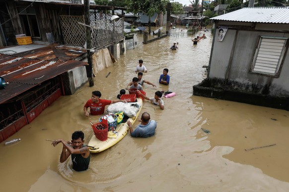 epa10206700 Residents wade through flood water caused by typhoon Noru in San Miguel town of Bulacan province, north of Manila, Philippines 26 September 2022. Typhoon Noru crossed the northern Philippi ...