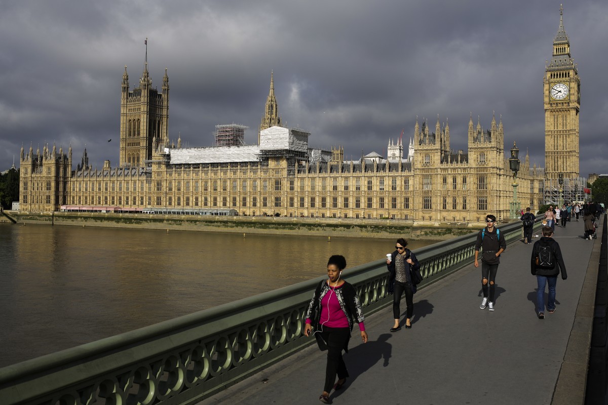 People cross Westminster Bridge in front of the Houses of Parliament the day after Britain's national elections on London, Friday, June 9, 2017. British Prime Minister Theresa May's gamble i ...