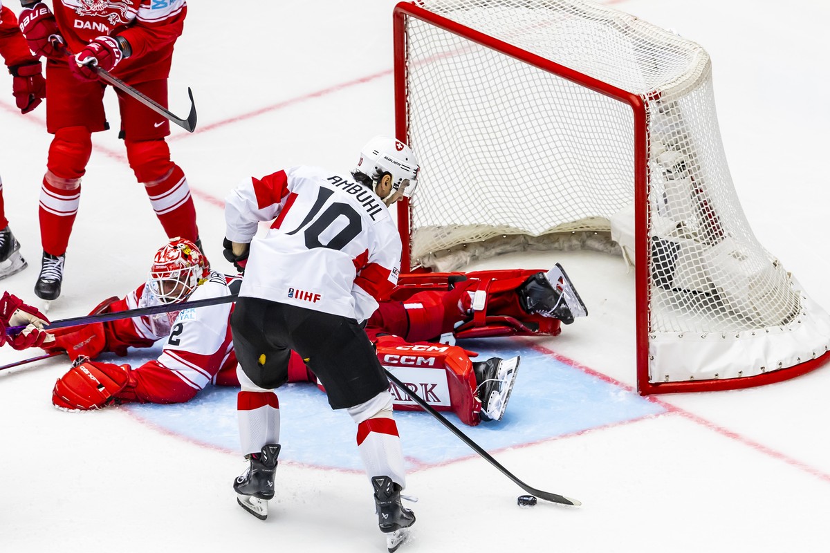 Switzerland's forward Andres Ambuehl #10, controls the puck past Denmark's goaltender Sebastian Dahm, during the IIHF 2025 World Championship preliminary round group B game between Denmark a ...