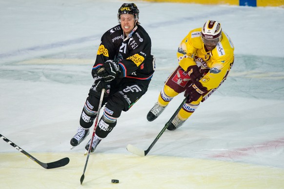 Le joueur fribourgeois Flavio Schmutz, gauche, lutte pour le puck avec le joueur genevois Auguste Impose, droite, lors du match du championnat suisse de hockey sur glace de National League LNA entre H ...