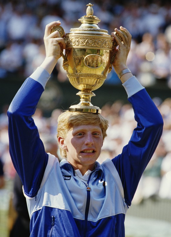 Boris Becker of Germany places the trophy on his head in to celebrate his defeat of Kevin Curren 6-3, 6-7 (4-7), 7-6 (7-3), 6-4 during the Men&#039;s Singles final of the Wimbledon Lawn Tennis Champio ...