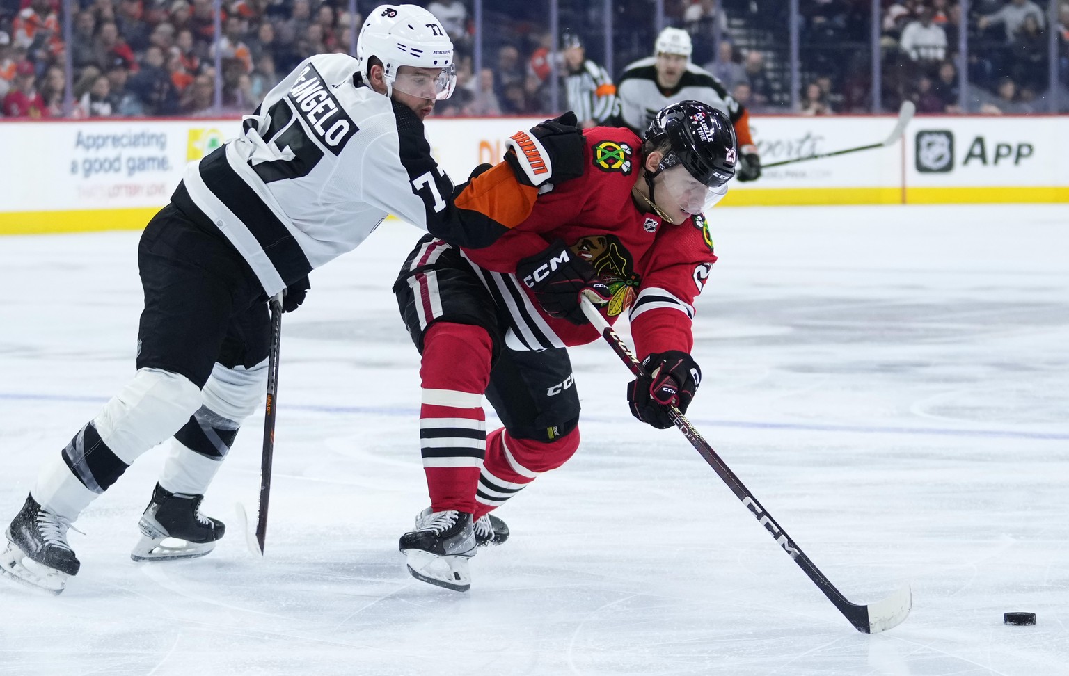 Chicago Blackhawks&#039; Philipp Kurashev, right, battles for the puck against Philadelphia Flyers&#039; Tony DeAngelo during the third period of an NHL hockey game, Thursday, Jan. 19, 2023, in Philad ...