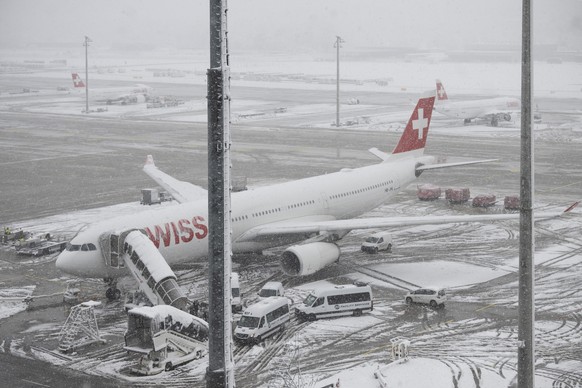 Fahrzeuge befreien den Flughafen von den verschneiten Pisten, aufgenommen am Samstag, 2. Dezember 2023 auf dem Flughafen in Zuerich. (KEYSTONE/Ennio Leanza)