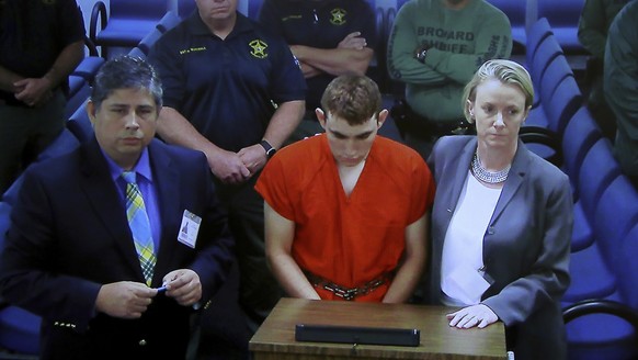 A video monitor shows school shooting suspect Nikolas Cruz, left, with public defender Melisa McNeill, making an appearance before Judge Kim Theresa Mollica in Broward County Court, Thursday, Feb. 15, ...