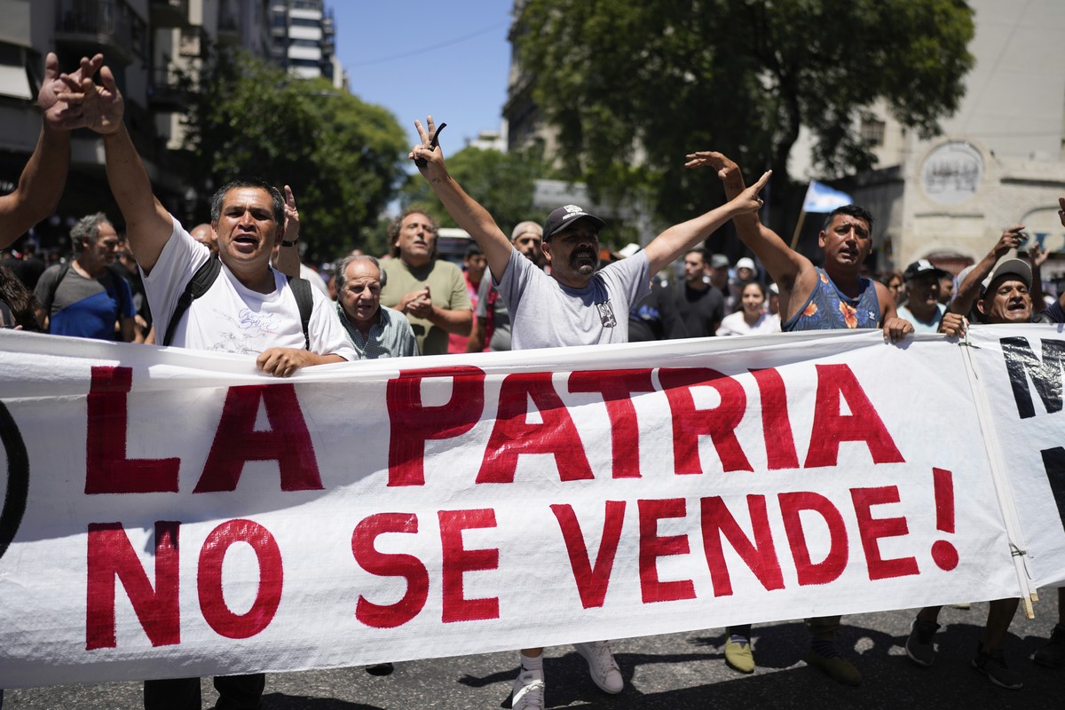 People march to Congress with a sign that reads in Spanish "You don't sell the country!" during a national strike against economic and labor reforms proposed by Argentine President Javi ...