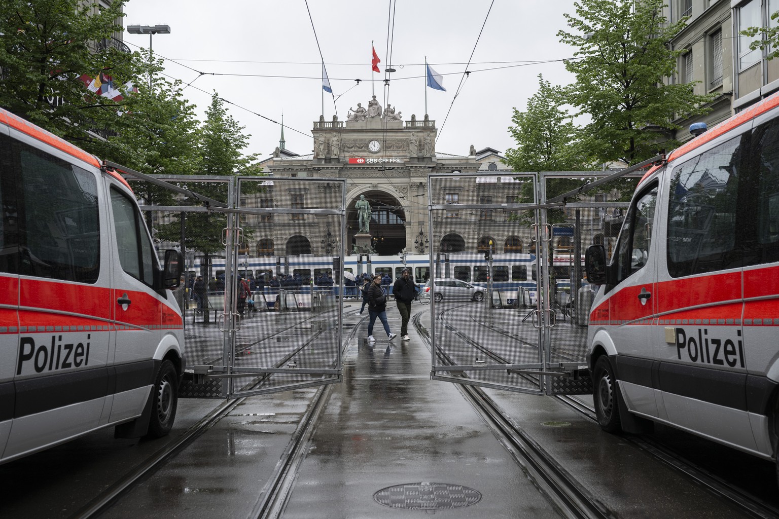 Polizisten schuetzen die Laeufer vor dle FCZ Fans an der Bahnhofstrasse am den 21. Zuercher Marathon ein, aufgenommen am Sonntag, 21. April 2024 in Zuerich. (KEYSTONE/Ennio Leanza)