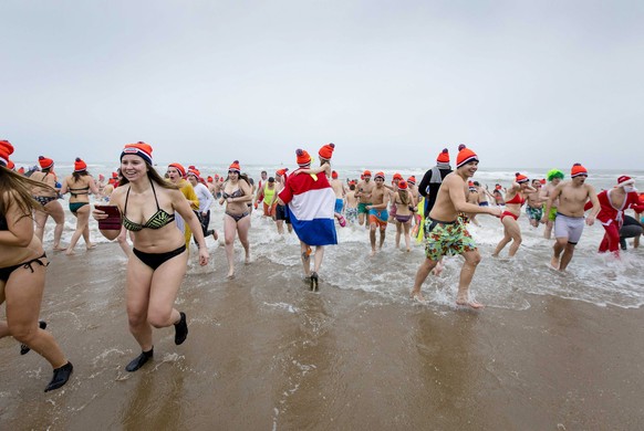 epa05694032 Costumed people get out of the North Sea during the Nieuwjaarsduik (New Year's Dive) on New Year's Day in Scheveningen, the Netherlands, 01 January 2017.  EPA/BART MAAT