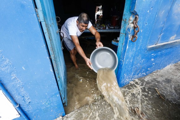 epa10206706 A resident uses a water basin to remove floodwater from a local eatery amid flooding caused by typhoon Noru in San Miguel town of Bulacan province, north of Manila, Philippines 26 Septembe ...