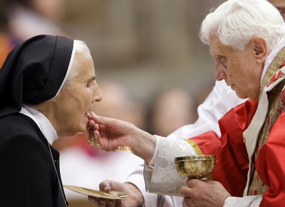 Pope Benedict XVI offers a nun the holy communion during a mass to mark the 50th anniversary of the death of Pope Pius XII, in St.Peter&#039;s Basilica at the Vatican Thursday, Oct. 9, 2008. The ponti ...