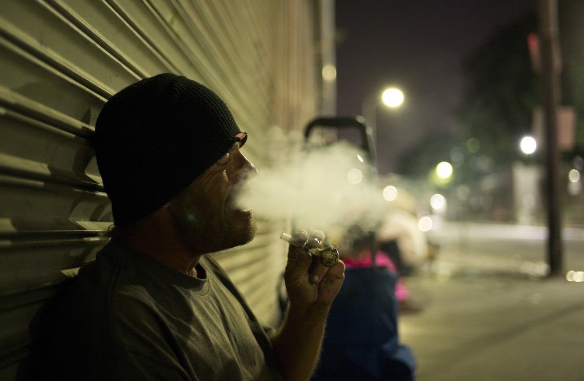 D. J. Meek, a 40-year-old homeless drug addict, smokes crystal meth Friday, Sept. 8, 2017, in the Skid Row area of downtown Los Angeles. Meeks' veins are collapsed due to chronic use of heroin. H ...
