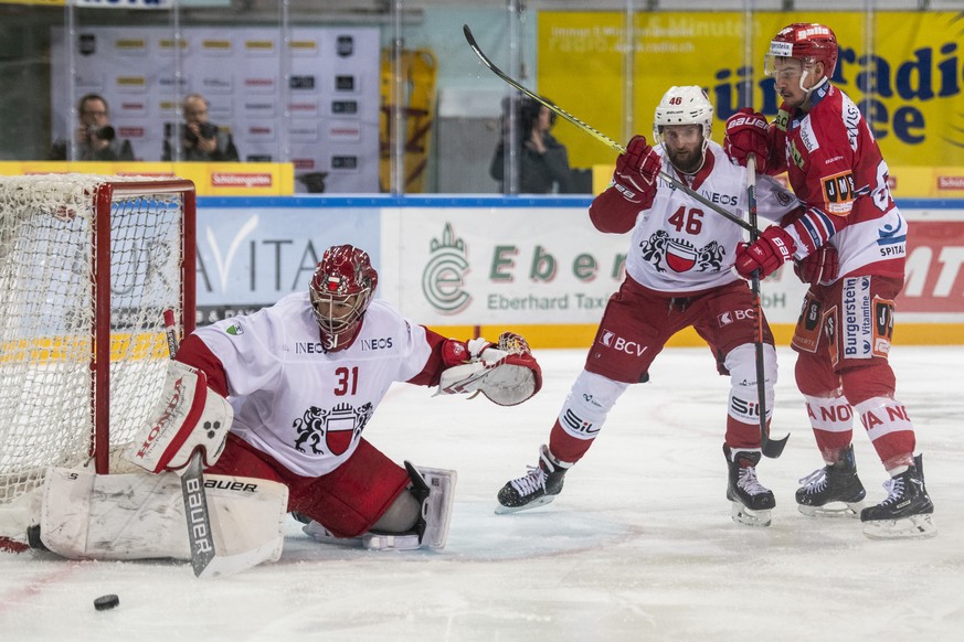 Lausannes Torhueter Sandro Zurkirchen, links, und Lausannes Benjamin Antonietti, Mitte, gegen SC Rapperswil-Jona Lakers Stuermer Fabian Brem, rechts, im Eishockey Meisterschaftsspiel der National Leag ...