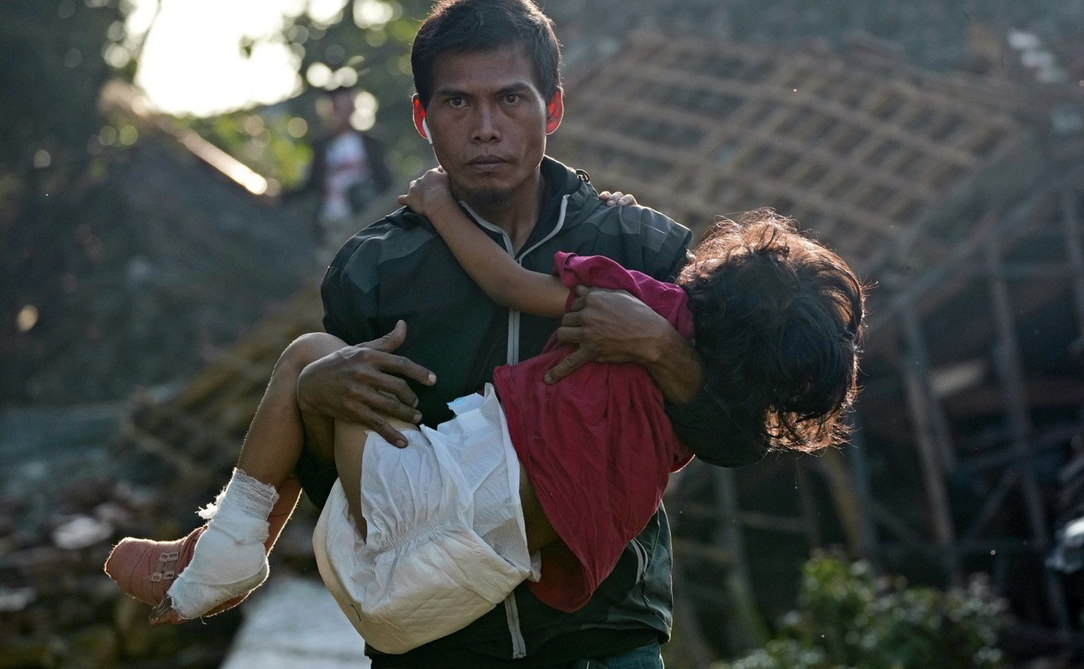 A man carries his injured daughter as they head to a temporary shelter for those displaced by Monday&#039;s earthquake in Cianjur, West Java, Indonesia, Thursday, Nov. 24, 2022. The 5.6 magnitude eart ...