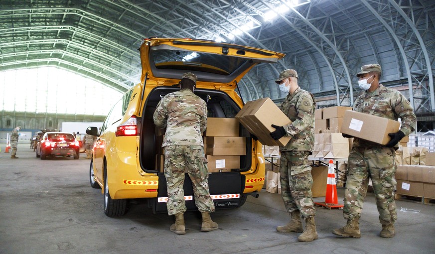 epa08375598 New York National Guardsmen load boxes of food into the back of taxi for delivery to people who are unable to leave their homes in the Kingsbridge Armory in the Bronx, New York, USA, 21 Ap ...