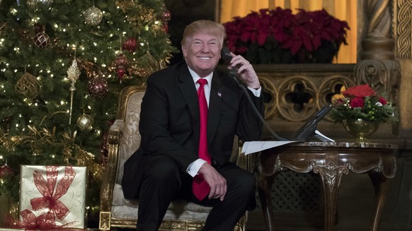 President Donald Trump smiles to the media as he speaks on the phone with children as they track Santa&#039;s movements with the North American Aerospace Defense Command (NORAD) Santa Tracker on Chris ...