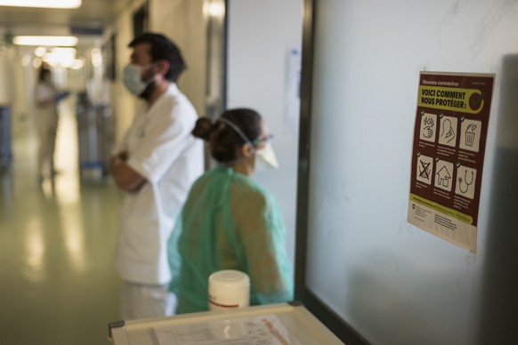 Eine Pflegefachfrau, rechts, und ein Soldat schauen gemeinsam nach Covid-19 Patienten, im Freiburger Spital (HFR), am Mittwoch, 8. April 2020 in Freiburg. Fuenfzig Spital- und Sanitaetssoldaten uebern ...