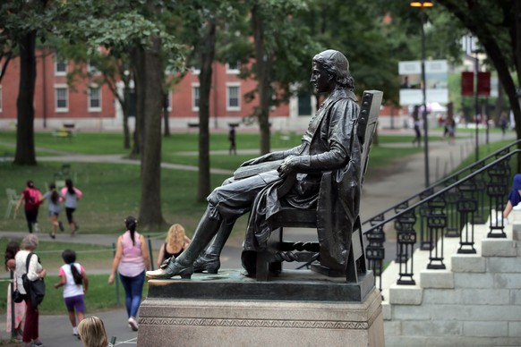 FILE - In this Aug. 13, 2019, file photo, the statue of John Harvard looks over Harvard Yard at Harvard University in Cambridge, Mass. A settlement was announced Wednesday, Nov. 27, in a 2015 federal  ...