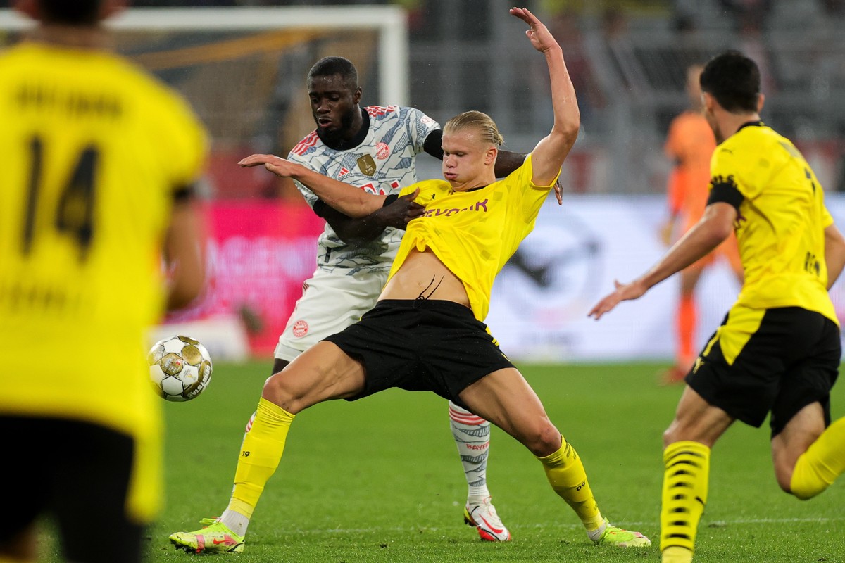 epa09418262 Dortmund's Erling Haaland (R) in action against Bayern's Dayot Upamecano (L) during the DFL Supercup 2021 soccer match between Borussia Dortmund and FC Bayern Muenchen in Dortmun ...