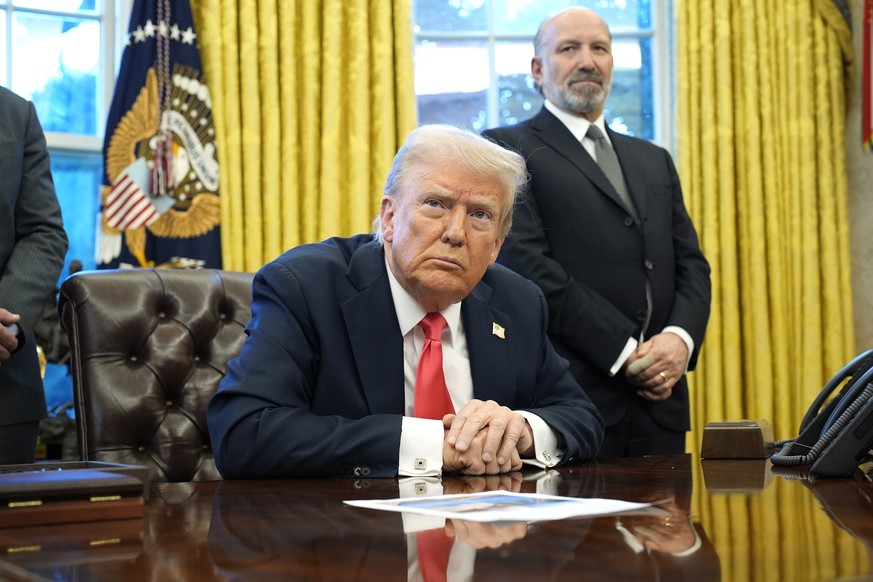 epa11924646 US President Donald Trump speaks to reporters alongside Secretary of Commerce Howard Lutnick (R) after signing Executive Orders in the Oval Office of the White House in Washington, DC, USA ...