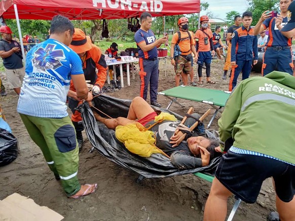 epa09887641 A handout photo made available by the Philippine Army (PA) - 14th Infantry Batallion shows a wounded victim carried on a makeshift stretcher after a village was struck by a landslide in th ...