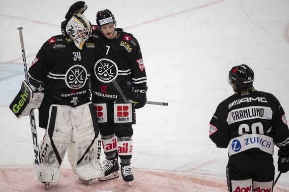 From left, Lugano?s goalkeeper Niklas Shlegel and Lugano?s player Daniel Carr celebrate the victory after the preliminary round game of the National League 2022/23 between HC Lugano against HC Ajoie a ...